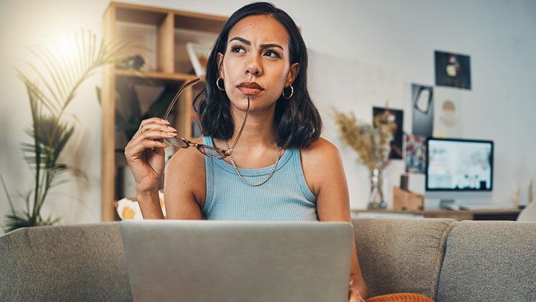 Woman sitting on couch thinking