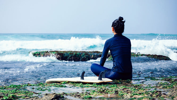 Woman sitting beside ocean