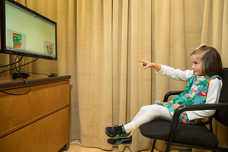 Child watching television and pointing 